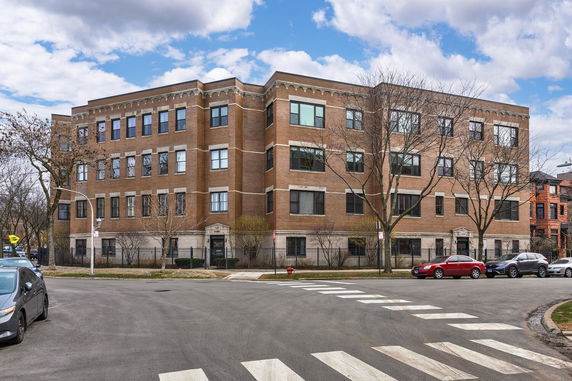 Front view of a four-story brick building with multiple windows.