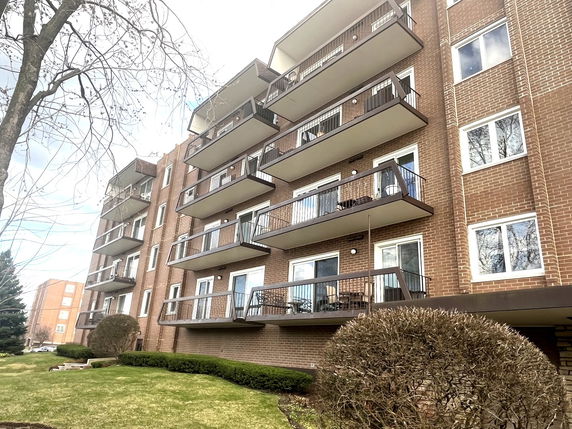 Front view of a multi-story apartment building with balconies.