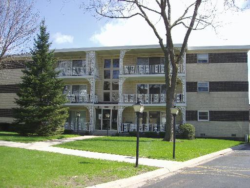 Front view of a three-story apartment building with balconies.
