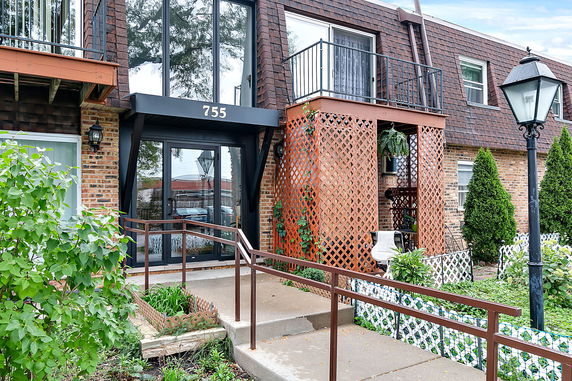 Front view of a multi-story building with a glass entrance and number 755 above the door.