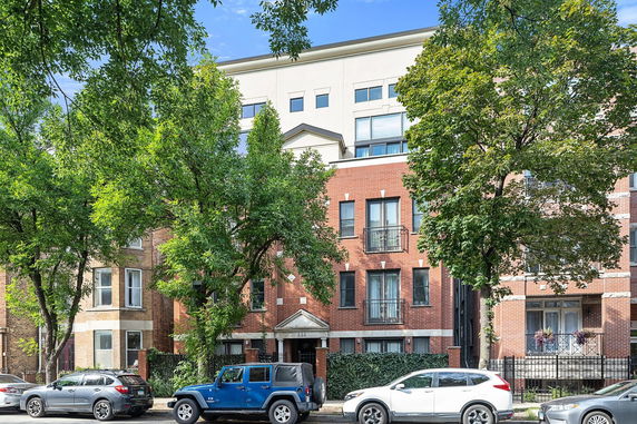 Front view of a multi-story apartment building with a brick facade.