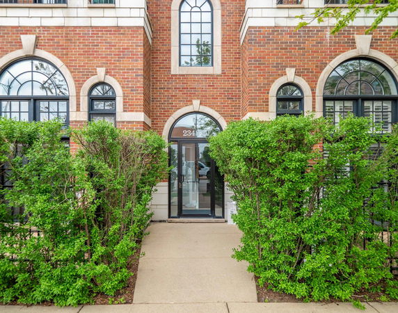 Front view of a brick building with arched windows and a central entrance.