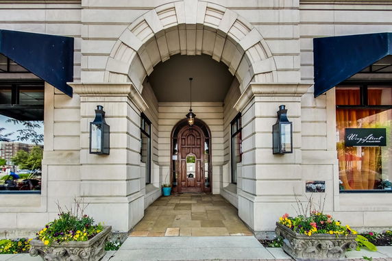 Front view of an entrance to a building with an archway and decorative lights.