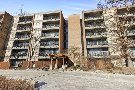 Front view of a multi-story apartment building with balconies.