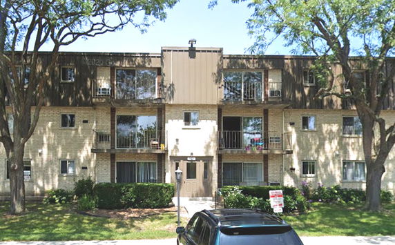 Front view of a three-story residential building with balconies.