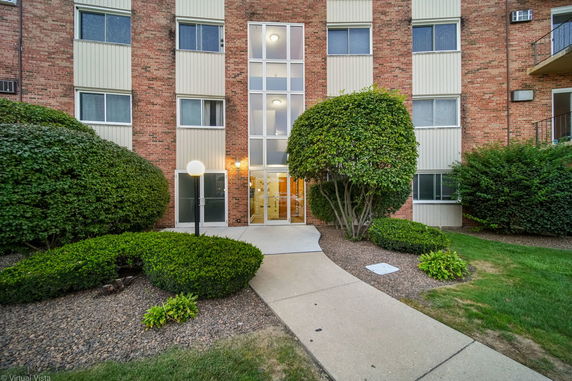 Front view of a multi-story brick building with large windows and a central entrance.