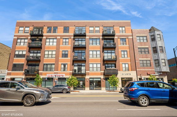 Front view of a multi-story brick building with balconies.