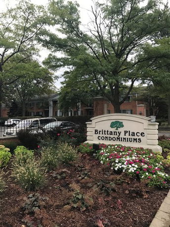 Front view of a multi-story condominium building with a sign reading 'Brittany Place Condominiums.'