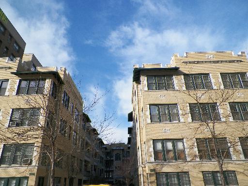 Front view of multiple apartment buildings under a blue sky.