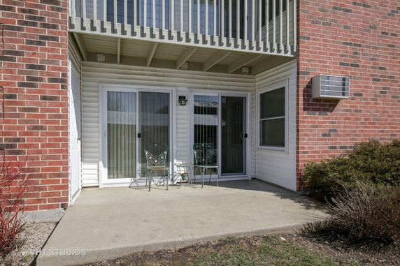 Front view of a building with sliding doors and a small patio area.