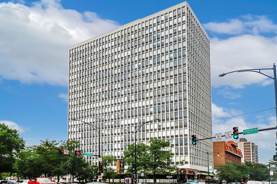 Front view of a tall high-rise building with a grid-like window design.