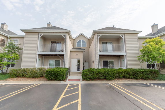 Front view of a two-story residential building with balconies and a central entrance.