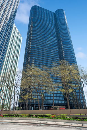 Front view of a tall, modern skyscraper with a glass facade.