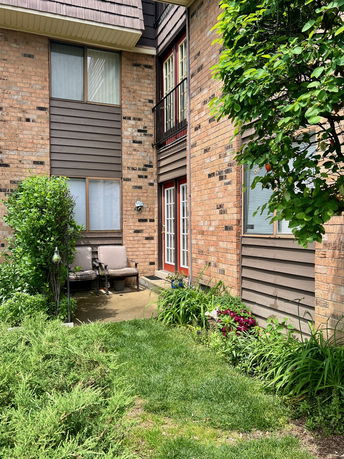 Front view of a house with brick exterior and small patio area.