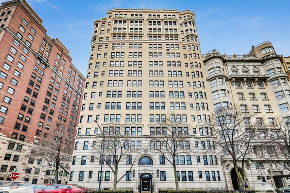 Front view of a tall apartment building with multiple windows.