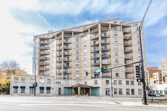 Front view of a multi-story apartment building with balconies on each floor.