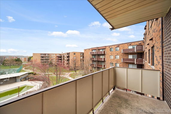 View from a balcony overlooking multiple brick residential buildings.