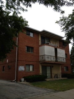 Front view of a multi-story brick apartment building.
