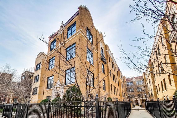Front view of a multi-story brick building with large windows and decorative architecture.