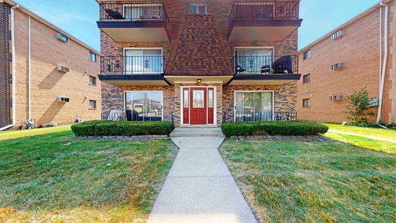 Front view of a multi-story residential building with balconies.