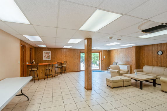 Interior view of a clubhouse with tiled flooring and seating area.