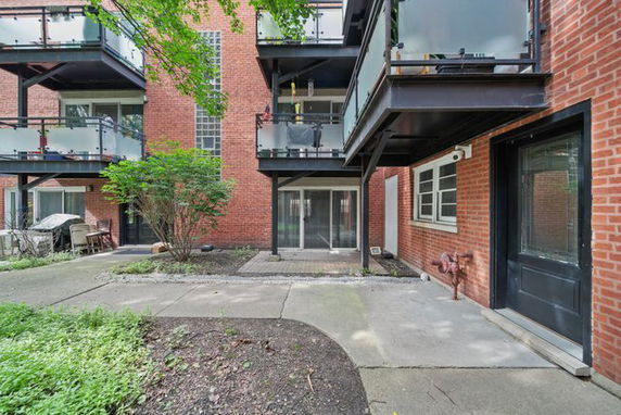 View of a brick building with balconies and a courtyard area.
