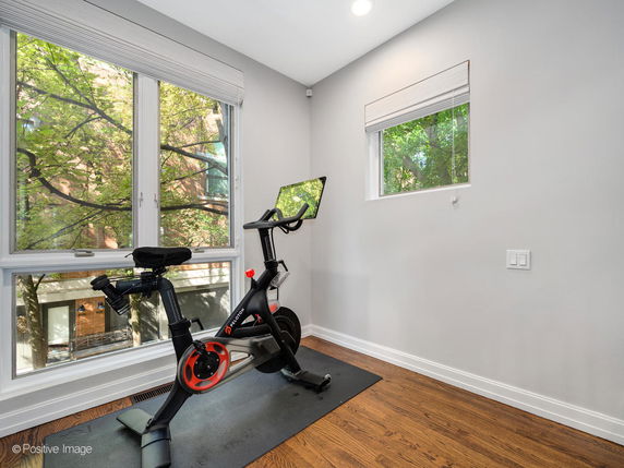 Room with an exercise bike and large windows.