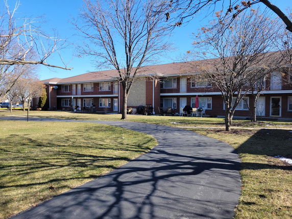Front view of a two-story brick apartment building with balconies.