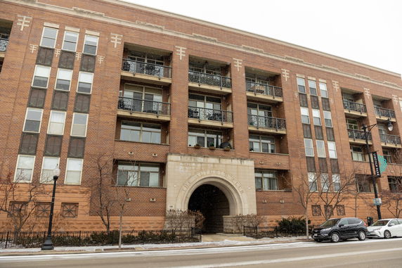 Front view of a multi-story brick building with balconies.