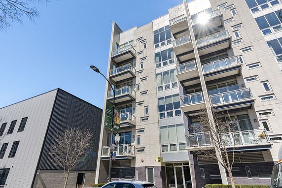 Front view of a multi-story apartment building with balconies.