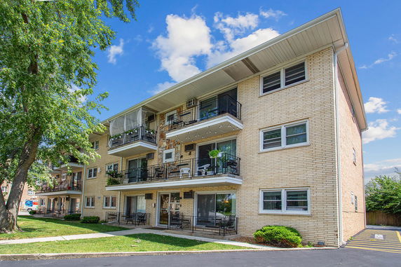 Front view of a multi-story apartment building with balconies.