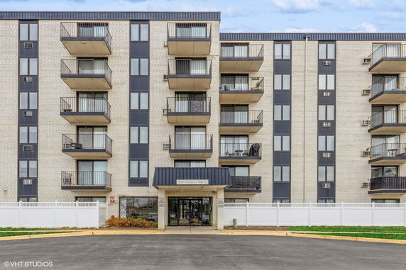Front view of a multi-story residential building with balconies.
