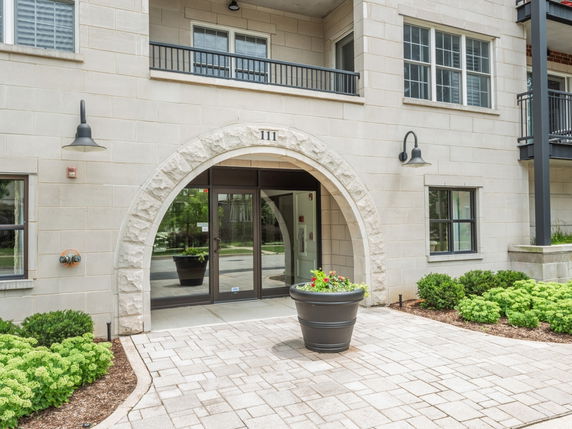 Front view of a multi-story building with an arched entrance.