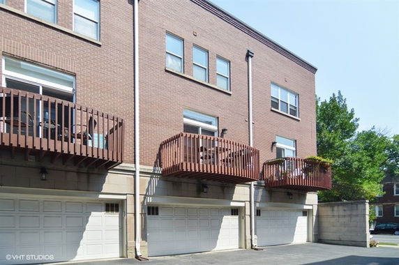 Front view of a multi-story building with balconies and garages.