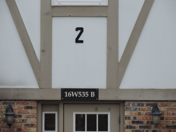 Front view of a building showing door and signage.