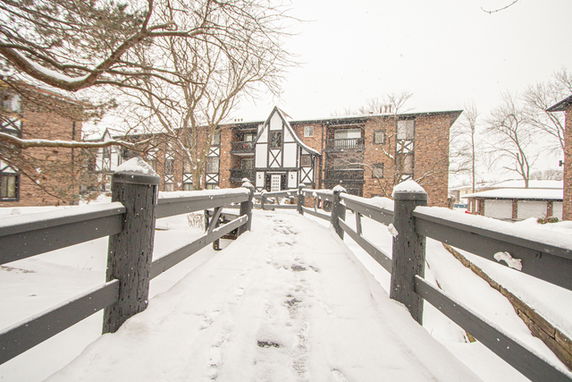Front view of a multi-story building with a Tudor-style facade, surrounded by snow.