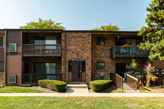 Front view of a two-story brick apartment building with balconies.