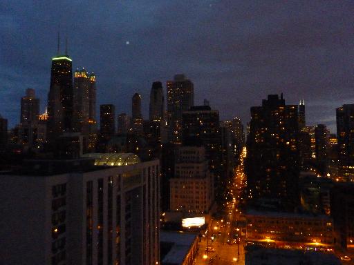 Panoramic view of a city skyline at night with illuminated buildings.