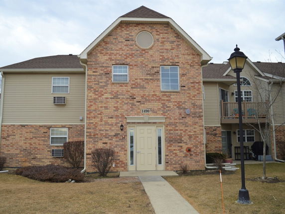 Front view of a two-story brick and siding house with a centered entrance.