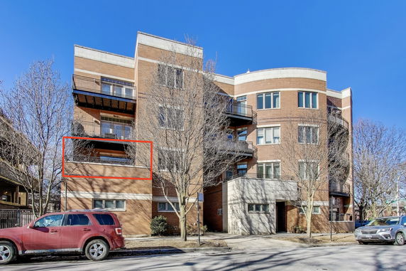 Front view of a multi-story brick building with balconies.