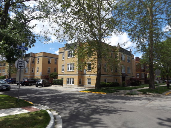 Front view of a multi-story apartment building on a street corner.