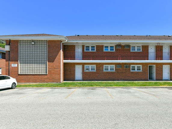Front view of a two-story brick apartment building with a patterned façade.