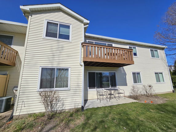 Front view of a two-story house with a balcony and patio area.