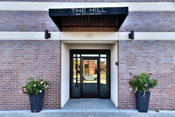 Entrance of a brick building with a glass door and canopy.
