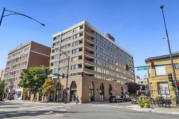 Front view of a multi-story commercial building at a street intersection.