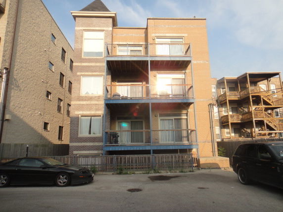 Rear view of a multi-story apartment building with balconies.