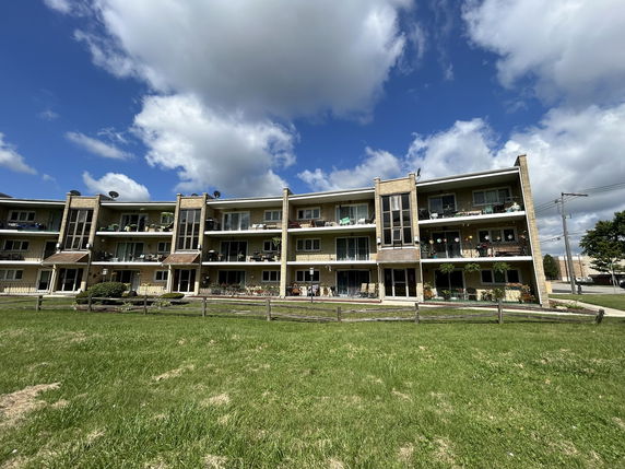 Front view of a three-story apartment building with balconies.