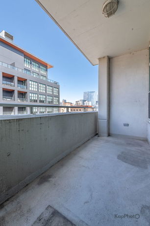 View from a balcony overlooking modern buildings in an urban area.