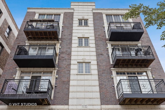 Front view of a multi-story building with multiple balconies.