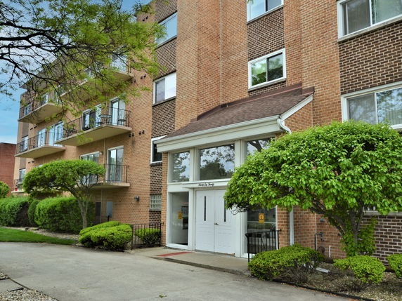 Front view of a multi-story apartment building with balconies.